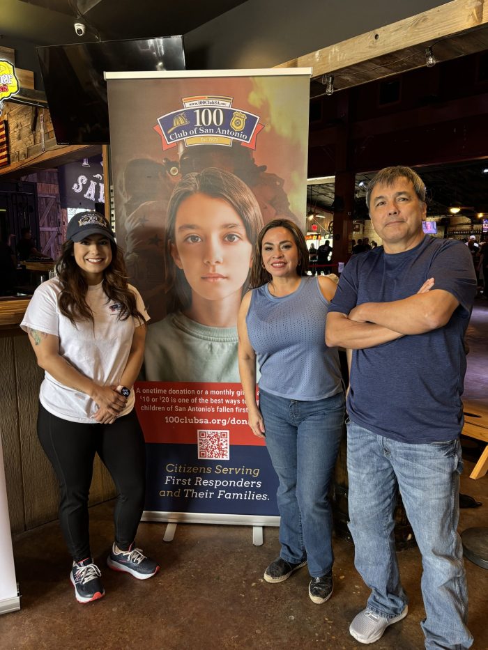 Three people standing in front of a banner.